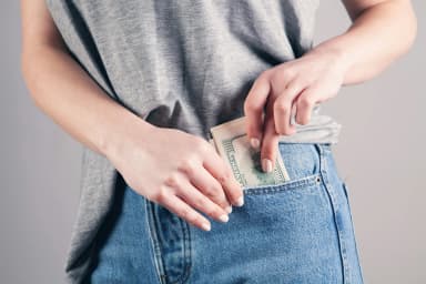 a person putting bills on their pocket